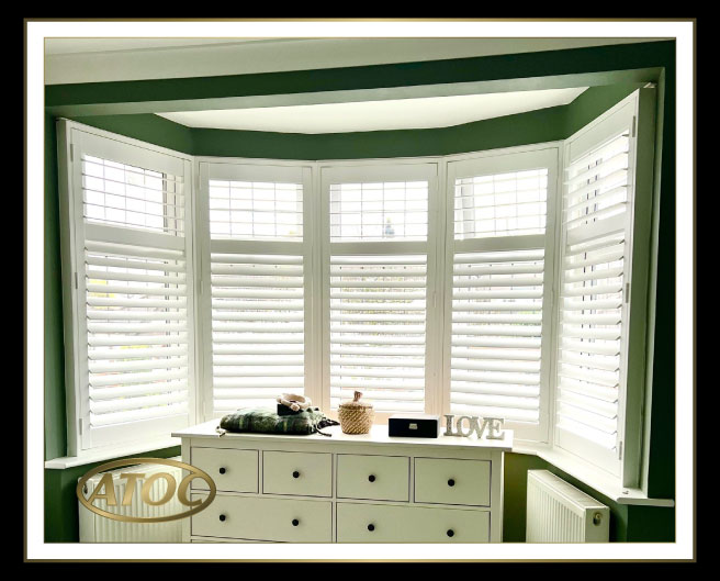 Full height plantation shutters covering the entire window in a modern Essex living room for privacy and light control