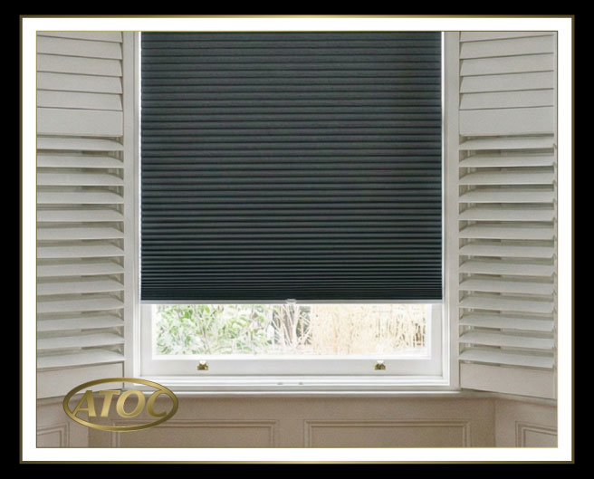 Close-up showing a pleated and cellular blackout blind integrated inside a plantation shutter frame with hidden tilt